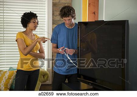 USA, Utah, Provo, couple installing new TV set View Large Photo Image Stock Photo - USA, Utah, Provo, couple installing new TV set. Fotosearch