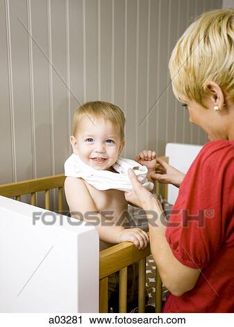 USA, Utah, Provo, Mother dressing baby boy (18-23 months) in crib View Large Photo Image Stock Image - USA, Utah, Provo, Mother dressing baby boy (18-23 months) in crib. Fotosearch