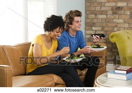 USA, Utah, Provo, young couple eating dinner, watching television View Large Photo Image Stock Image - USA, Utah, Provo, young couple eating dinner, watching television. Fotosearch