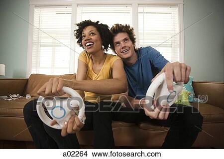 USA, Utah, Provo, young couple playing video games in living room View Large Photo Image Picture - USA, Utah, Provo, young couple playing video games in living room. Fotosearch