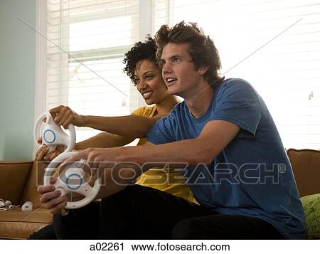 USA, Utah, Provo, young couple playing video games in living room View Large Photo Image Stock Image - USA, Utah, Provo, young couple playing video games in living room. Fotosearch