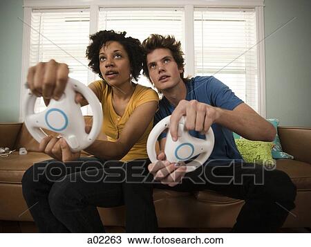 USA, Utah, Provo, young couple playing video games in living room View Large Photo Image Stock Image - USA, Utah, Provo, young couple playing video games in living room. Fotosearch