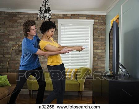 USA, Utah, Provo, young couple using remote control in living room View Large Photo Image Stock Photo - USA, Utah, Provo, young couple using remote control in living room. Fotosearch