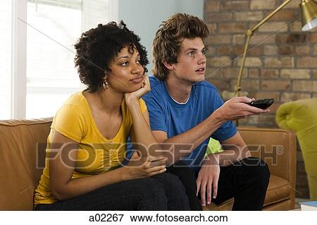 USA, Utah, Provo, young couple watching television in living room View Large Photo Image Stock Photo - USA, Utah, Provo, young couple watching television in living room. Fotosearch