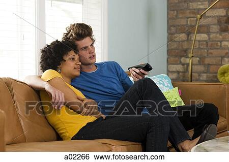 USA, Utah, Provo, young couple watching television in living room View Large Photo Image Stock Photograph - USA, Utah, Provo, young couple watching television in living room. Fotosearch