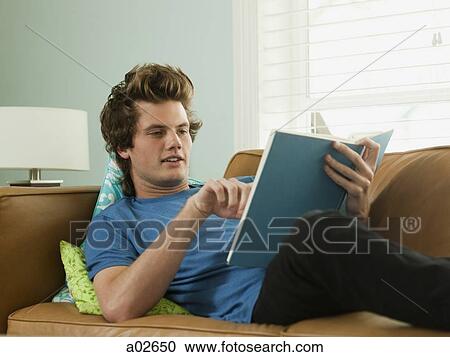 USA, Utah, Provo, young man lying down on sofa and reading book View Large Photo Image Stock Image - USA, Utah, Provo, young man lying down on sofa and reading book. Fotosearch