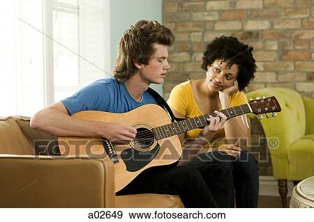 USA, Utah, Provo, young man playing guitar and young woman listening him View Large Photo Image Stock Photo - USA, Utah, Provo, young man playing guitar and young woman listening him. Fotosearch
