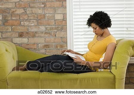 USA, Utah, Provo, young woman lying down on sofa and reading book View Large Photo Image Stock Image - USA, Utah, Provo, young woman lying down on sofa and reading book. Fotosearch
