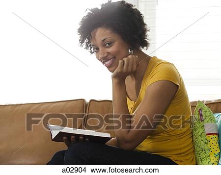 USA, Utah, Provo, young woman reading book on couch, portrait View Large Photo Image Picture - USA, Utah, Provo, young woman reading book on couch, portrait. Fotosearch