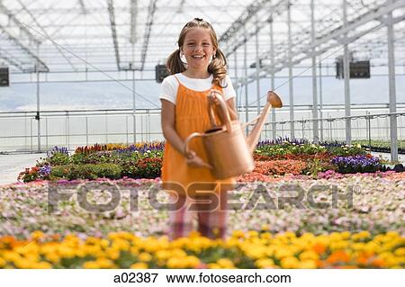 Stock Photo - USA, Utah, Salem, portrait of girl (8-9) in greenhouse. Fotosearch