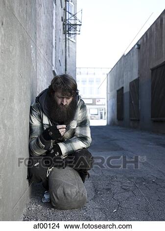 Picture - USA, Utah, Salt Lake City, Homeless man with sack by roadside. Fotosearch