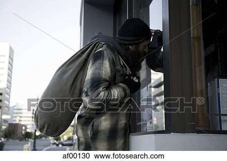 USA, Utah, Salt Lake City, Homeless man looking through window holding sack View Large Photo Image Stock Image - USA, Utah, Salt Lake City, Homeless man looking through window holding sack. Fotosearch
