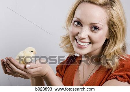 Stock Image - woman holding a baby chick. Fotosearch
