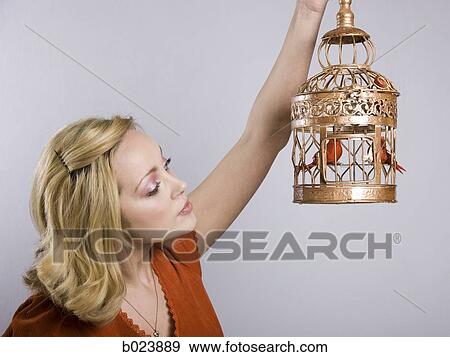 woman holding a birdcage View Large Photo Image Stock Photo - woman holding a birdcage. Fotosearch
