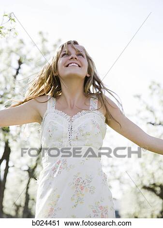 Stock Image - woman in a blossoming orchard. Fotosearch