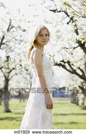 Stock Photo - woman in a blossoming orchard. Fotosearch