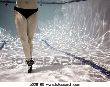 Stock Image - woman in a pool with ballet shoes on. Fotosearch