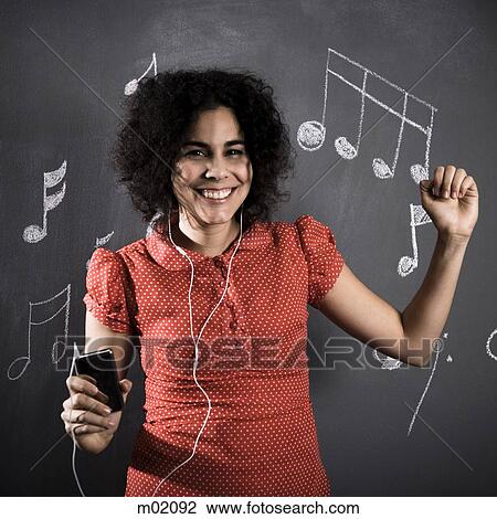 Stock Image - woman listening to mp3 player. Fotosearch