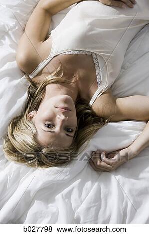 Stock Photo - woman lying on the bed. Fotosearch