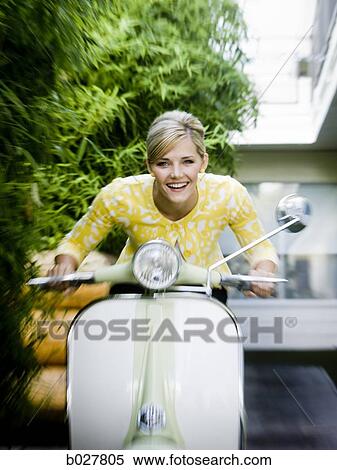 Stock Photography - woman on a classic scooter. Fotosearch