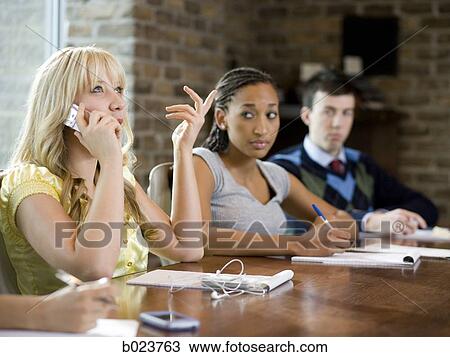 woman on her cell phone during a meeting View Large Photo Image Stock Image - woman on her cell phone during a meeting. Fotosearch