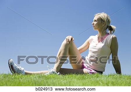 woman sitting on the grass stretching View Large Photo Image Stock Image - woman sitting on the grass stretching. Fotosearch