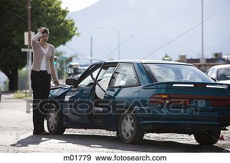 Stock Photo - woman standing by her car after an accident. Fotosearch