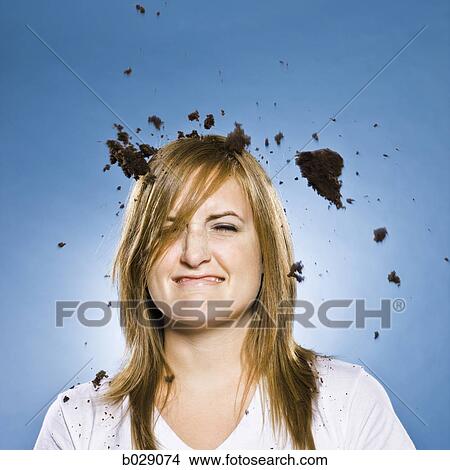 Picture - woman with cake falling on her head. Fotosearch