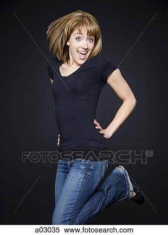 Young cheerful woman jumping, studio shot View Large Photo Image Stock Photography - Young cheerful woman jumping, studio shot. Fotosearch