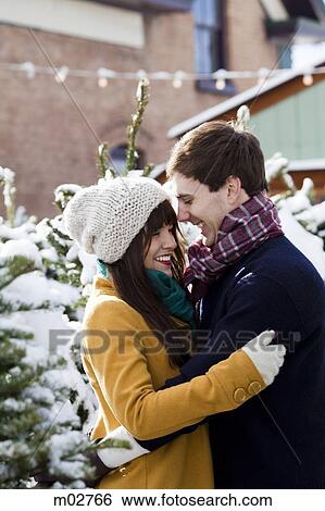 Stock Photograph - young couple getting a christmas tree in the snow. Fotosearch