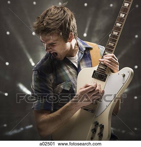 Young man playing bass guitar, studio shot View Large Photo Image Stock Image - Young man playing bass guitar, studio shot. Fotosearch