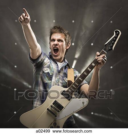 Young man playing bass guitar, studio shot View Large Photo Image Stock Photo - Young man playing bass guitar, studio shot. Fotosearch