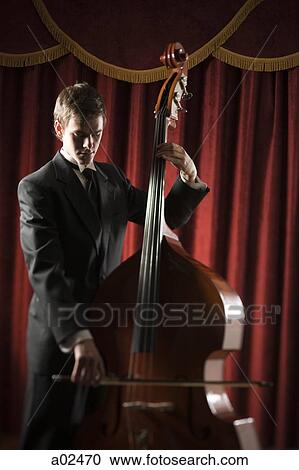 Young man playing double bass View Large Photo Image Stock Image - Young man playing double bass. Fotosearch