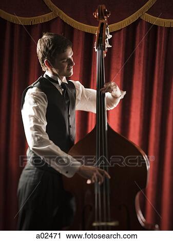 Young man playing double bass View Large Photo Image Stock Image - Young man playing double bass. Fotosearch
