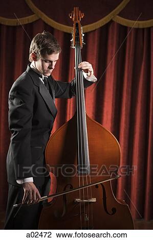 Young man playing double bass View Large Photo Image Stock Image - Young man playing double bass. Fotosearch