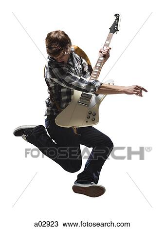 Young man playing electric guitar and jumping View Large Photo Image Stock Image - Young man playing electric guitar and jumping. Fotosearch