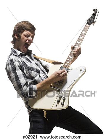 Young man playing electric guitar, shouting View Large Photo Image Stock Image - Young man playing electric guitar, shouting. Fotosearch