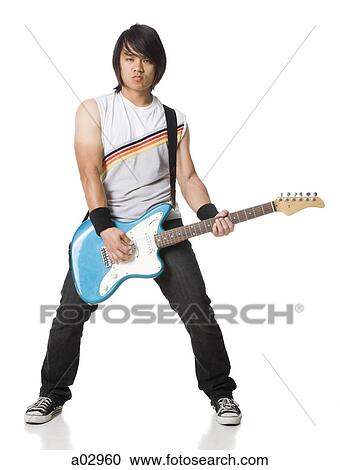 Young man playing electric guitar, portrait View Large Photo Image Stock Image - Young man playing electric guitar, portrait. Fotosearch
