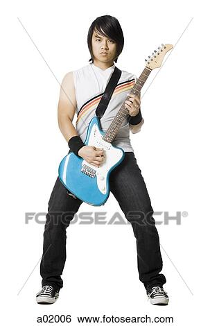 Young man playing electric guitar, studio shot View Large Photo Image Stock Photograph - Young man playing electric guitar, studio shot. Fotosearch