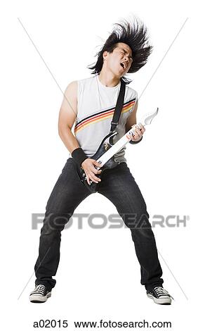 Stock Photography - Young man playing guitar video game and screaming, studio shot. Fotosearch
