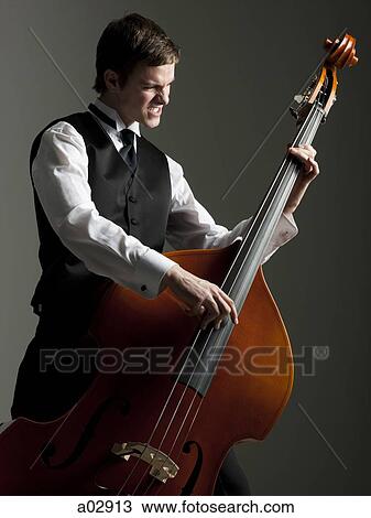 Stock Image - Young man plucking bauble bass. Fotosearch