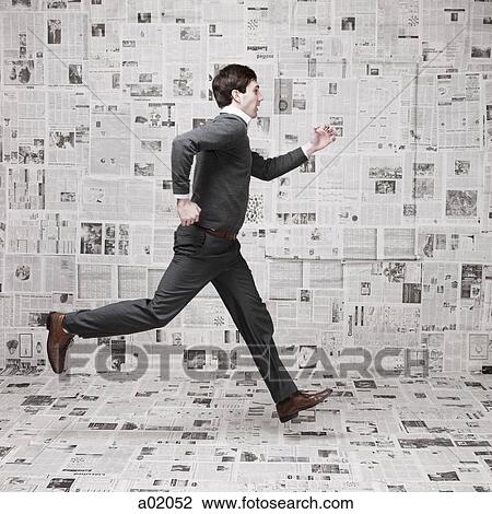 Young man running in front of wall covered with newspapers View Large Photo Image Stock Image - Young man running in front of wall covered with newspapers. Fotosearch
