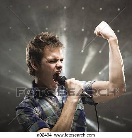 Picture - Young man singing, studio shot. Fotosearch