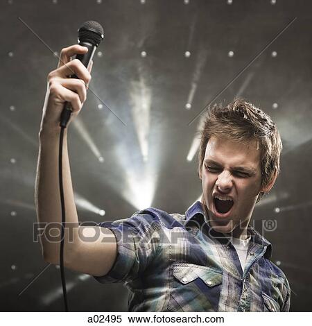 Stock Photography - Young man singing, studio shot. Fotosearch