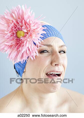 Stock Image - Young woman dressed as a baby, portrait, studio shot. Fotosearch