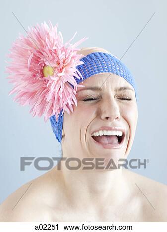 Stock Image - Young woman dressed as a baby, studio shot. Fotosearch