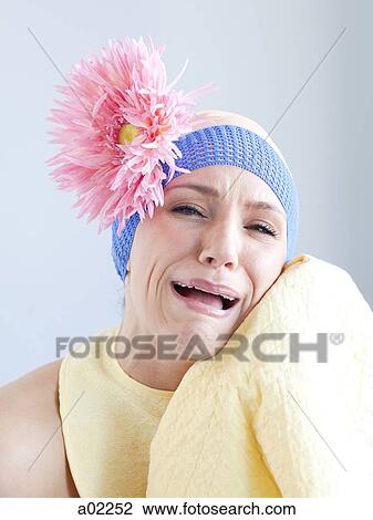 Stock Image - Young woman dressed as a baby, studio shot. Fotosearch