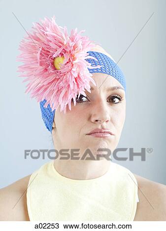 Stock Image - Young woman dressed as a baby, studio shot. Fotosearch