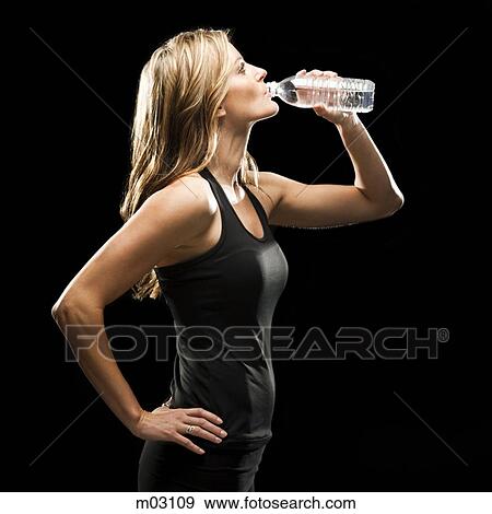 Stock Photo - Young woman drinking water from bottle. Fotosearch