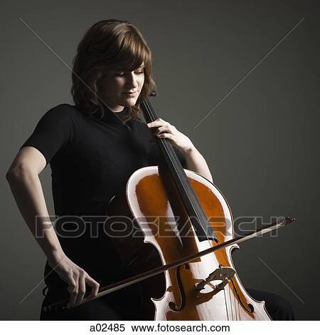 Stock Photography - Young woman playing cello, studio shot. Fotosearch